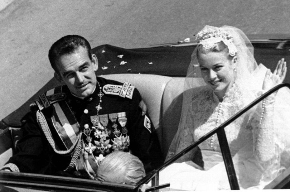 Princess Grace Kelly rides in an open car with Prince Rainier III following their marriage in a religious wedding ceremony in the Monaco Cathedral, 1956.