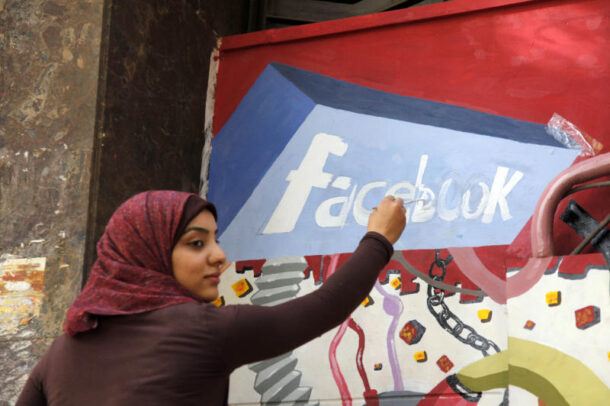 An art student paints the Facebook logo on a mural commemorating the revolution that overthrew Hosni Mubarak in the Zamalek neighborhood of Cairo, Egypt.