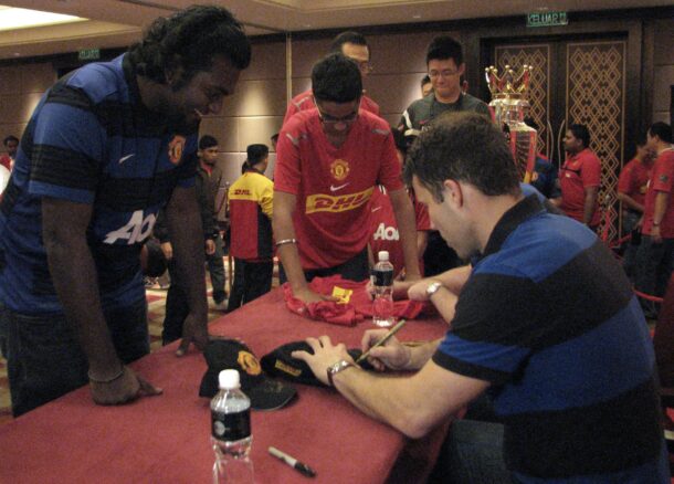 A lucky fan having his cap signed by Ronny.