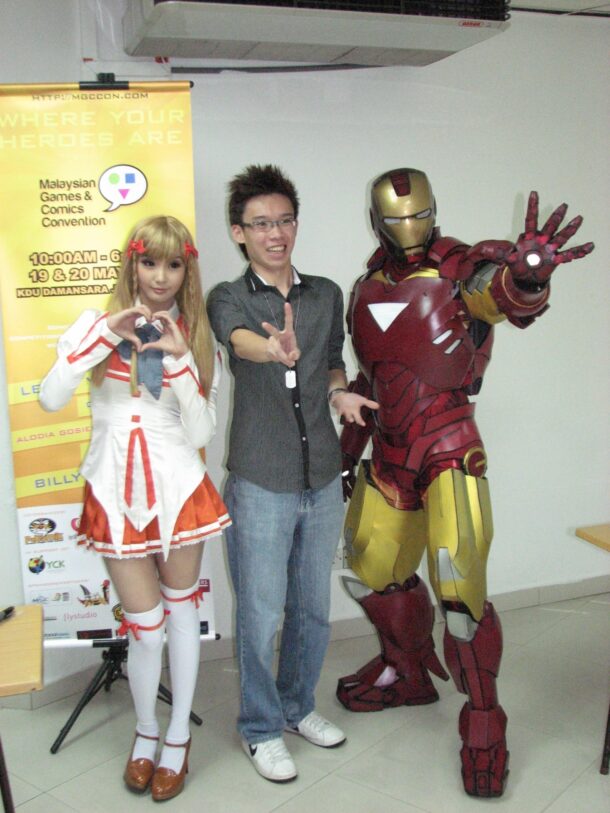 A lucky fan having his picture taken with Alodia and an Iron Man cosplayer A lucky fan posing with renowned Filipina cosplayer Alodia Gosiengfao (L) and, of course Iron Man, at the Malaysian Games and Comics Convention 2012.