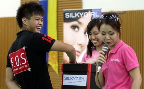 STAR A participant playing the 'mystery box' game, led by Alliance Cosmetics Sdn Bhd senior advertising and promotion manager Ng Su Si (right).