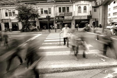 Slow shutter creates ghost like effect on walking pedestrian, creating an interesting photo.