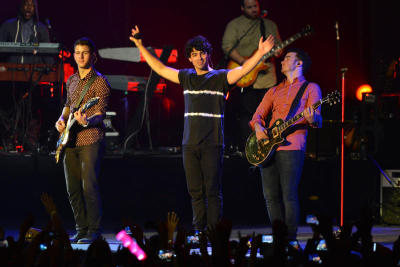 The Jonas Brothers standing in the middle of the stage as they end their set of the concert.