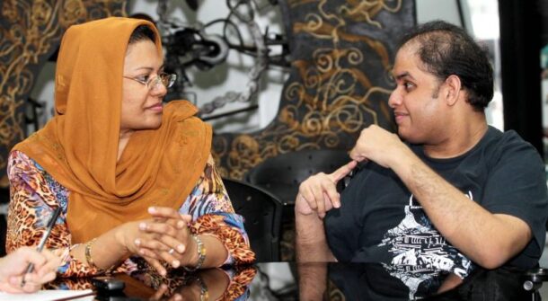 Hafiz using sign language for his mother to intepret during the interview.