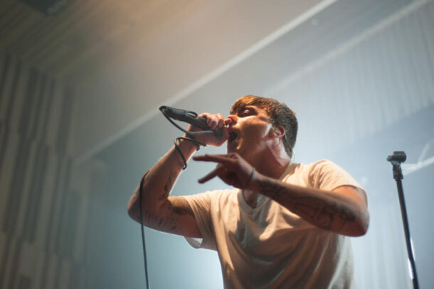 Circa Survive frontman Anthony Green interacting with the crowd while displaying his raw high-pitched vocals.