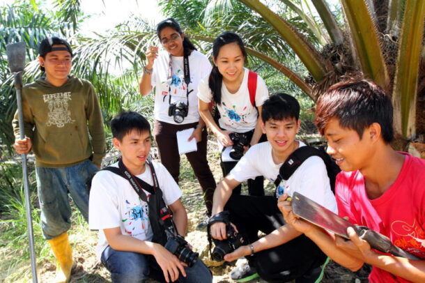 Achmad Mutaqin (R) showing the BRATs how sharp and heavy the iron rod used by oil palm plantation workers is.