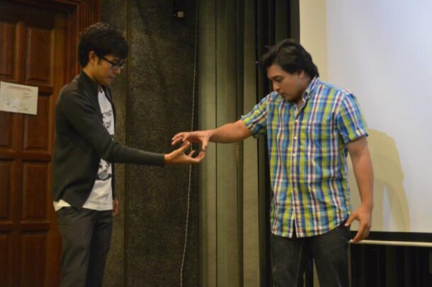 Razif Hasim (right) focuses on picking up the participant's imaginary ball.