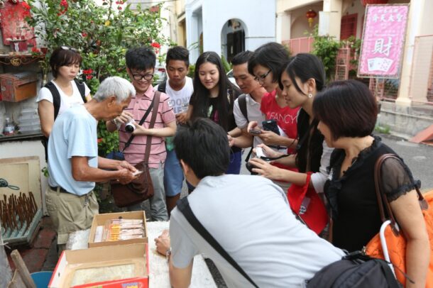 Participants of the Heritage In Penang heritage tour visiting a traditional trader. Arts-ED encourages youth participation in heritage preservation through social media and the arts.