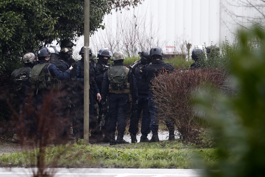 An image from EPA showing police officers preparing for an assault on the building where the two suspects are holding a hostage.