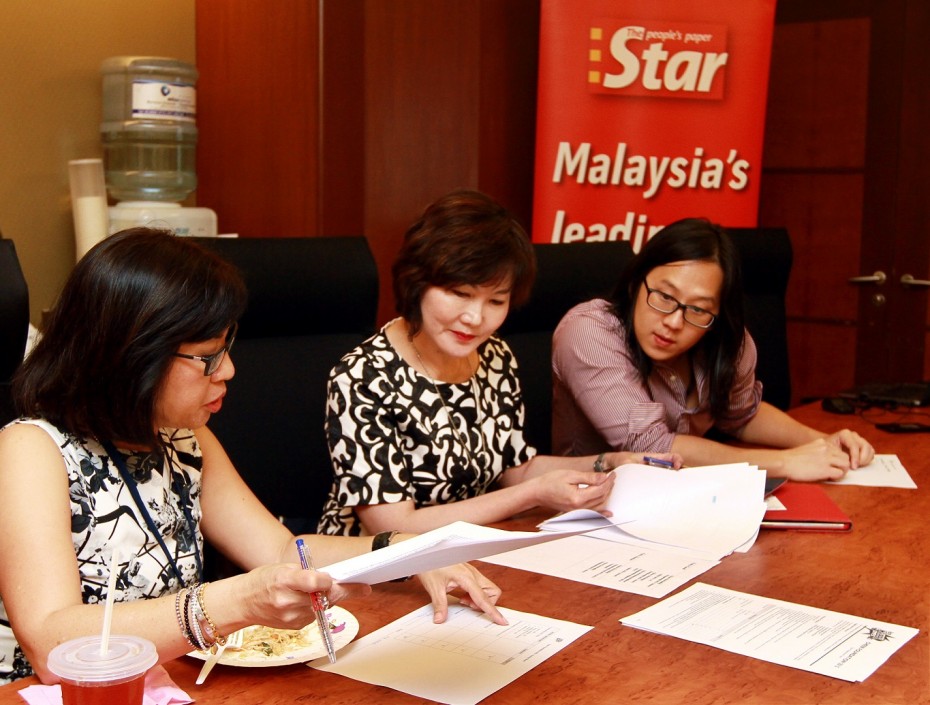 Tough call: Lee, Wong and Yee judging the applications for the CHEER Foundation grant. Cheerleading teams from across the country applied for the grant, which will see three teams receiving RM10,000 each. Photos: CHAN TAK KONG/The Star
