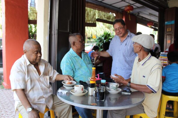 David (standing) often chats with his regulars. Ali Wahab, 58, (left) has been going to Restoran Hua Mui for over 40 years and likes that it has kept its old-school kopitiam look.
