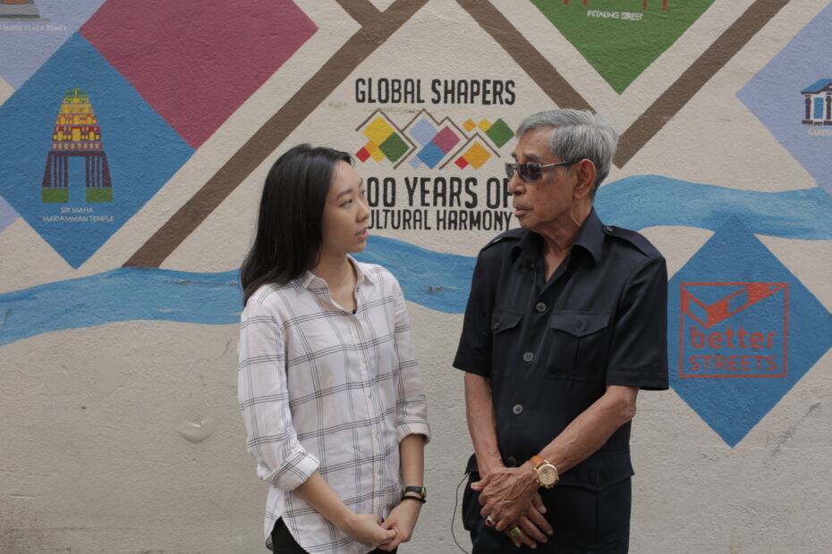 Robson (right) pictured during the filming of the Last Survivors, behind Sri Mahamariammam temple. His relative was taken and tortured by the Kempeitai in a building opposite the temple, which is now a bank.