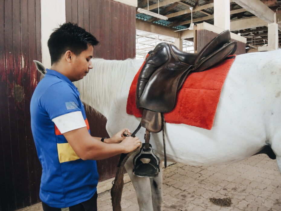 Muhammad tying the stirrup of the saddle on his horse, SW Pampero to ensure the safety and comfort of a good ride so as to avoid any form of injuries.